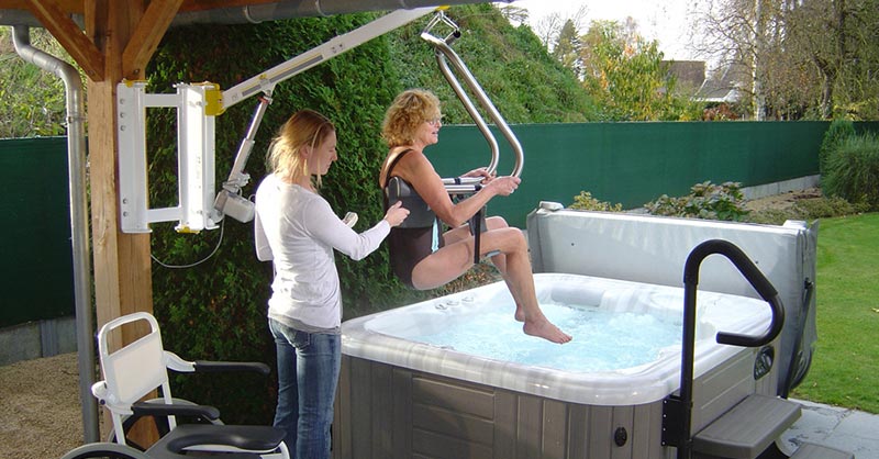 Ein Poollift transportiert eine Frau in den Whirlpool