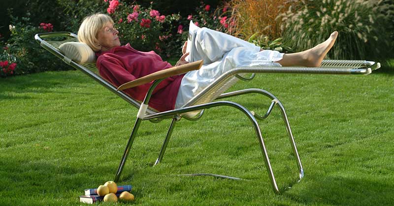 Frau entspannt im Liegestuhl im Garten