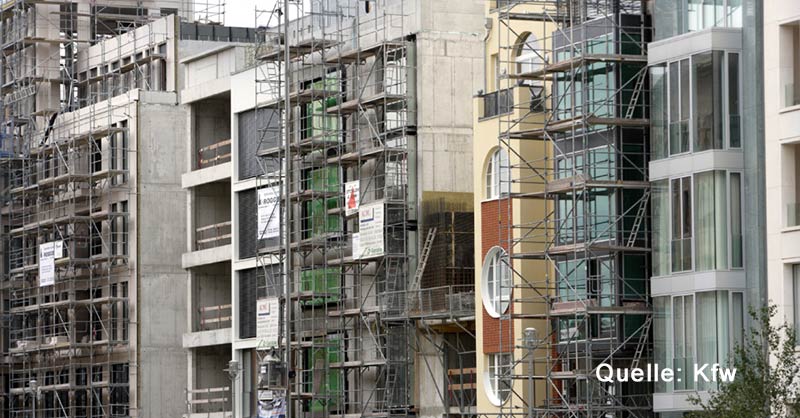 Baugerüste vor Rohbauten moderner Stadthäuser in unterschiedlichen Architekturstilen