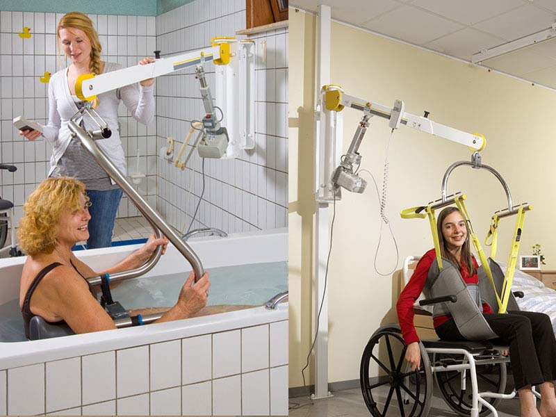 Frau mit Wandlifter in der Badewanne des Pflegebades, Wandlifter hebt Frau aus dem Rollstuhl